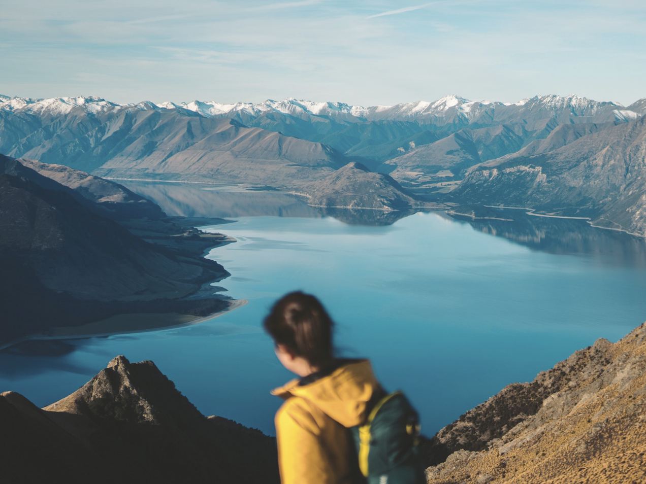A walker looking out over a mountain lake